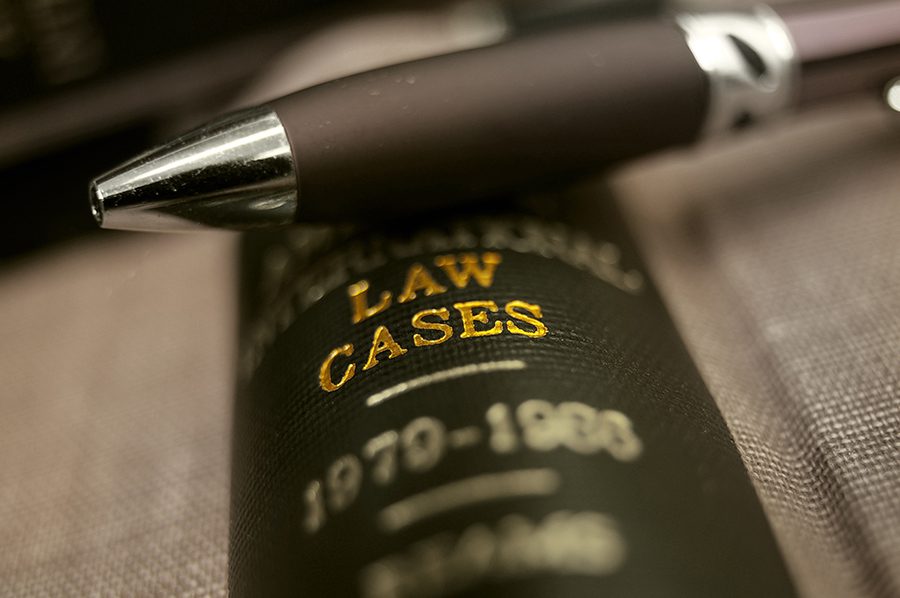 Close up of the spine of a book that says "Law cases" with a pen resting on top of the book spine